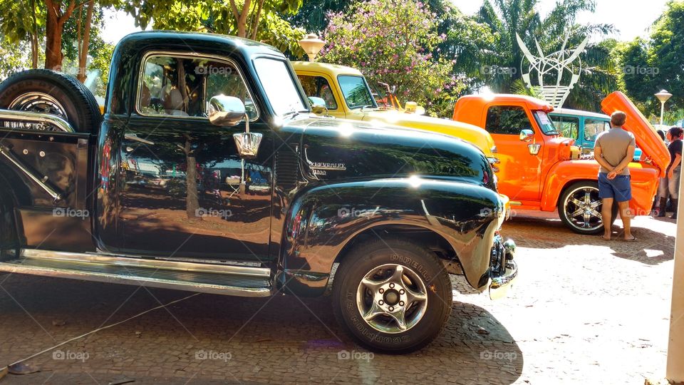 Camionetes antigas restauradas, exposições de veículos. Preta, amarela e laranja.