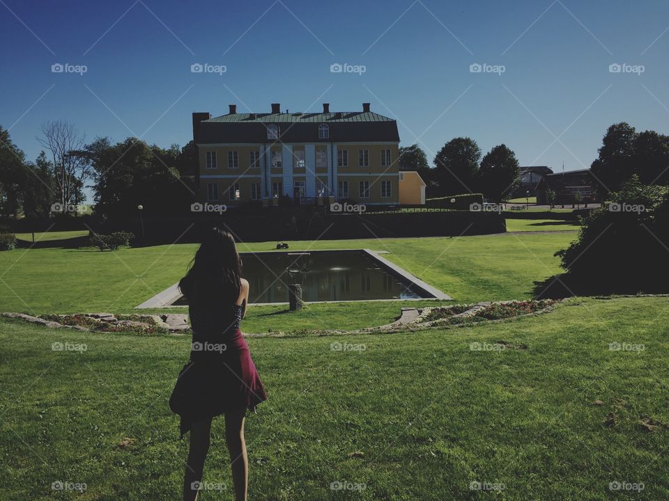 Girl in front of a big house in a park