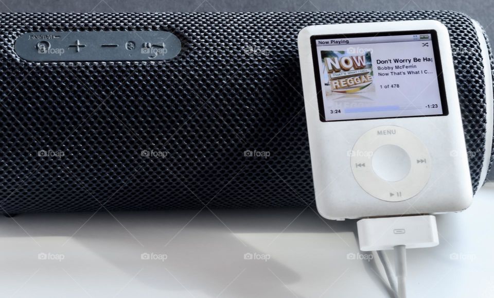 Apple iPod leaning against a portable speaker