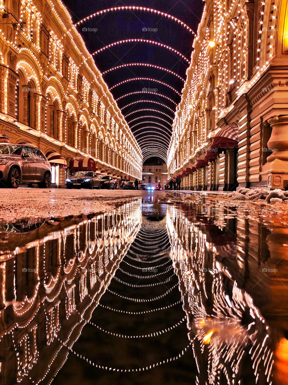 Illumination of a night street with reflection in a puddle