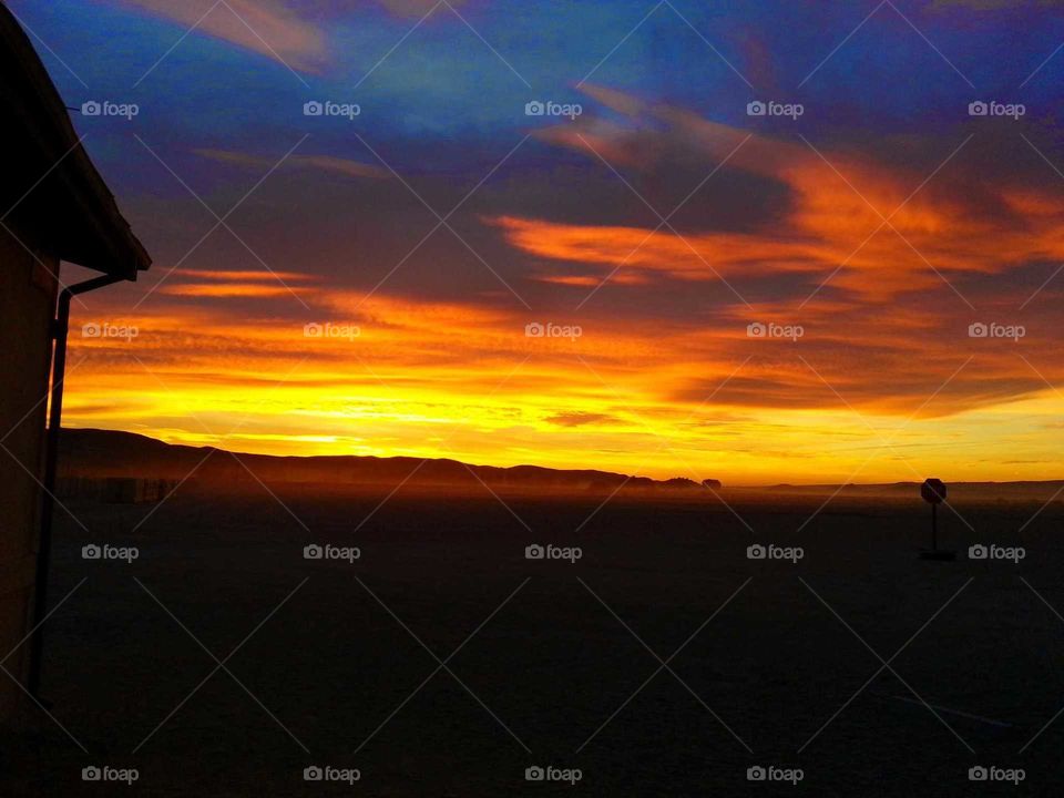 sunrise in the desert with bright orange, yellow, red and blue colors