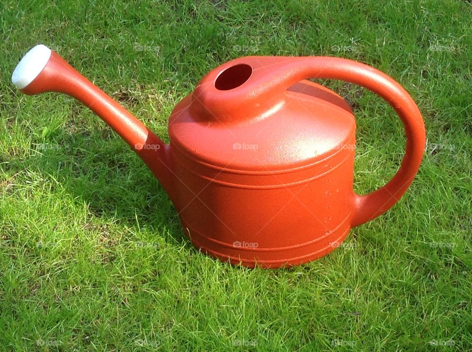 An orange watering can.