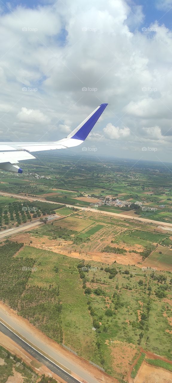 View from a landing airplane out the window of city.