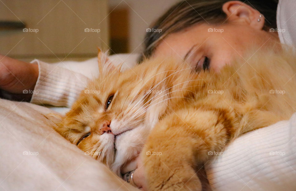 A ginger cat and woman sleeping