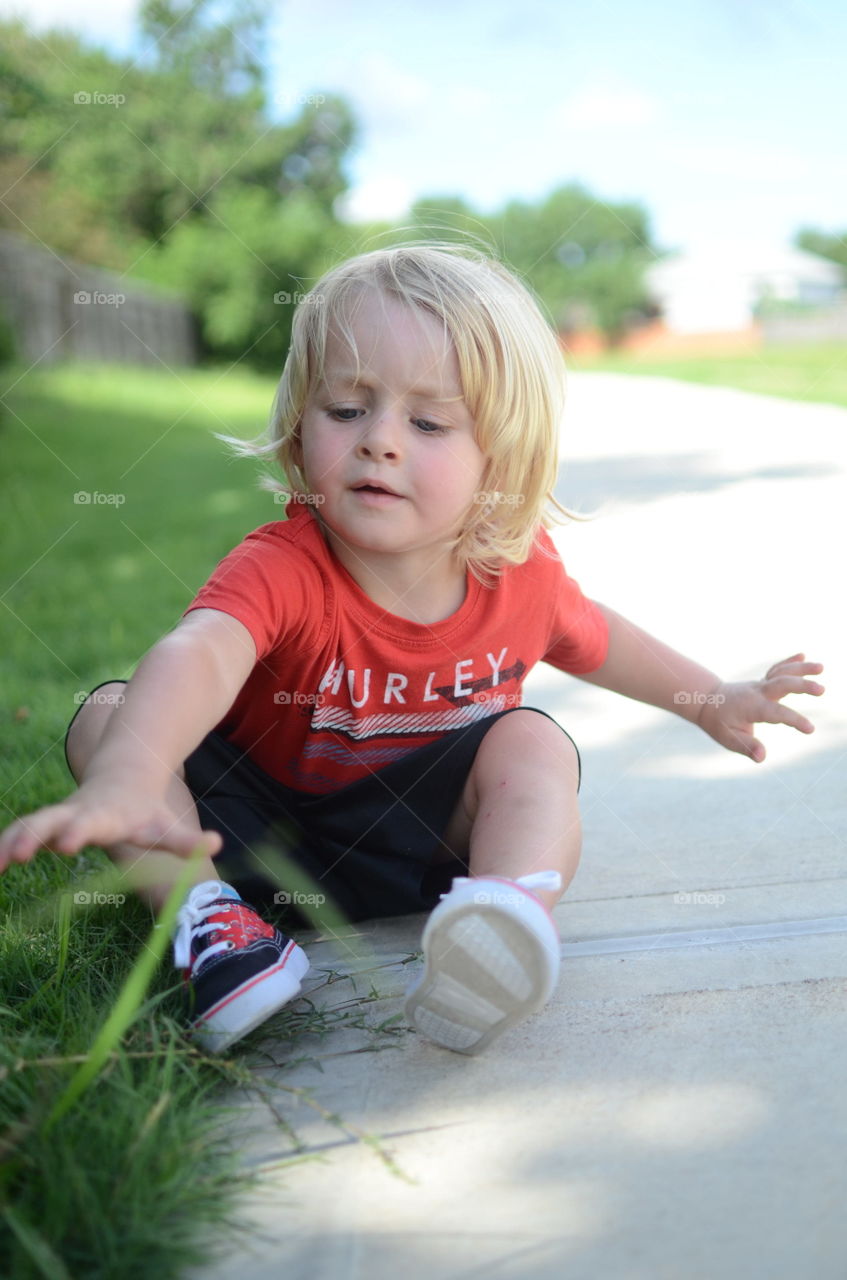 Portrait of boy sitting near the grass