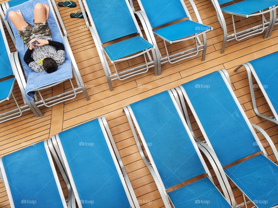 deck chairs with a single person reclining photographed from above