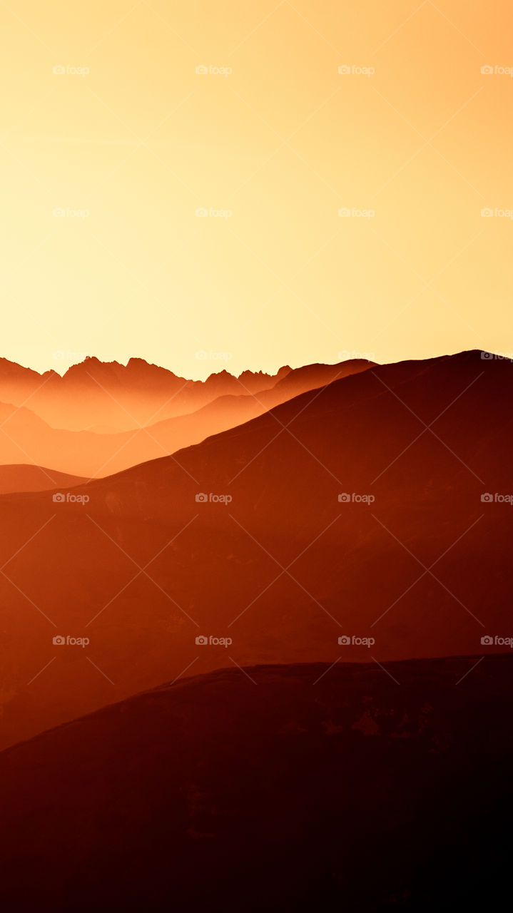 An inspiring red mountain landscape. Tatry mountains in Slovakia. A beautiful wallpaper for smartphone screen. Red abstract gradient with perspective.