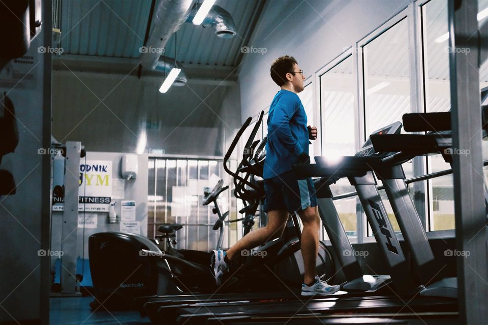 A man in a sports uniform runs on a treadmill