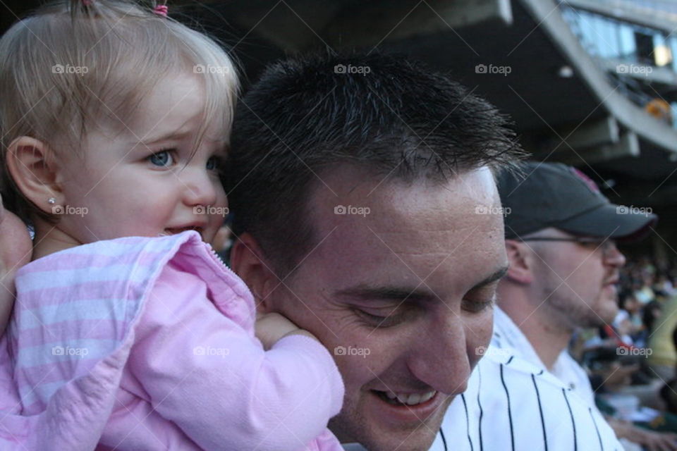 Dad and daughter at a baseball game in Oakland California 