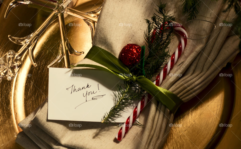 Christmas and new year seasons greeting thank you card on holiday festive place setting with traditional candy cane ornament and evergreen with crystal snowflake elegant holiday season photography background with golden colors 