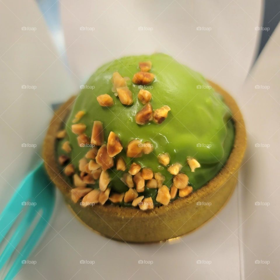 Matcha mousse tart  with nut particles on top