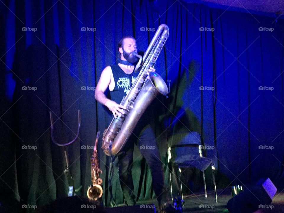 A dude with a giant saxophone on the stage