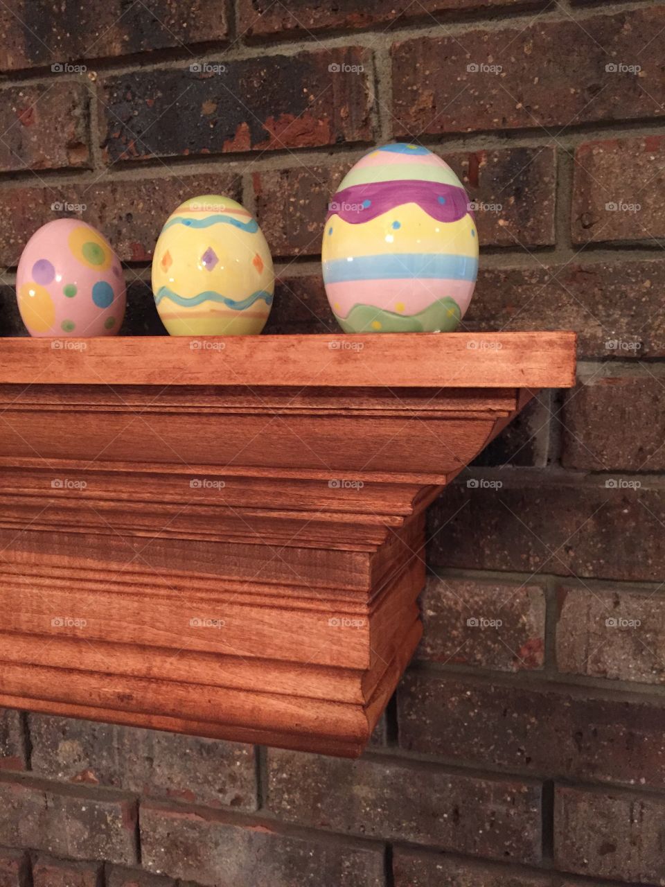 Easter eggs on shelves against brick wall