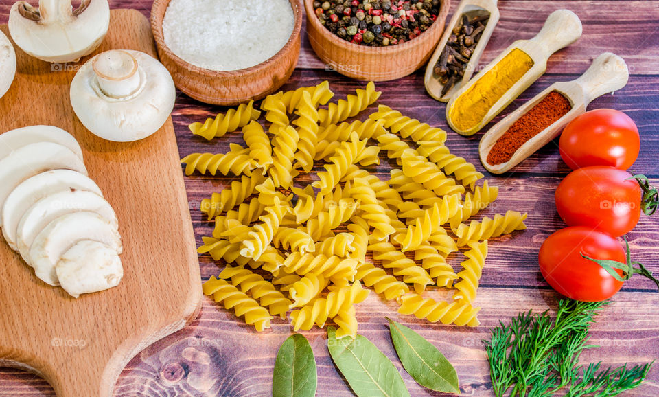 Raw pasta with ingredients and wooden accessories