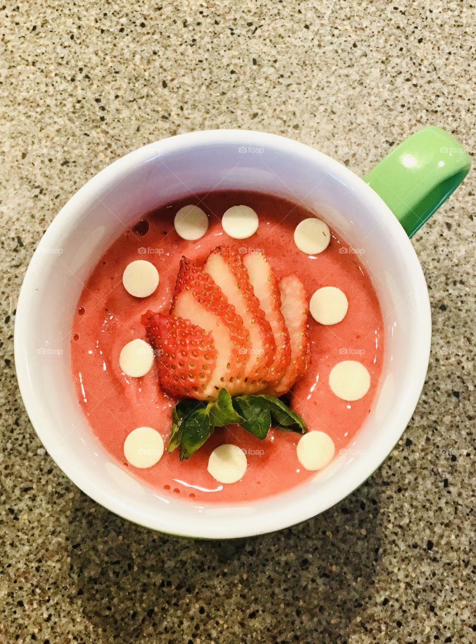 Delicious cup of strawberry smoothie with sliced strawberry and white chocolate cups! 