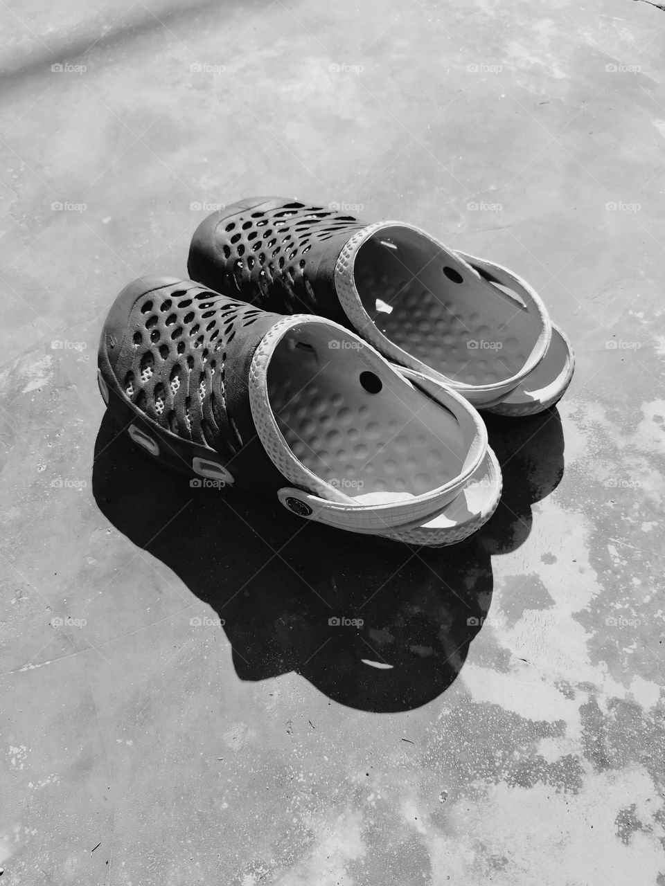 Shadow of sandals on the floor during the sunlight