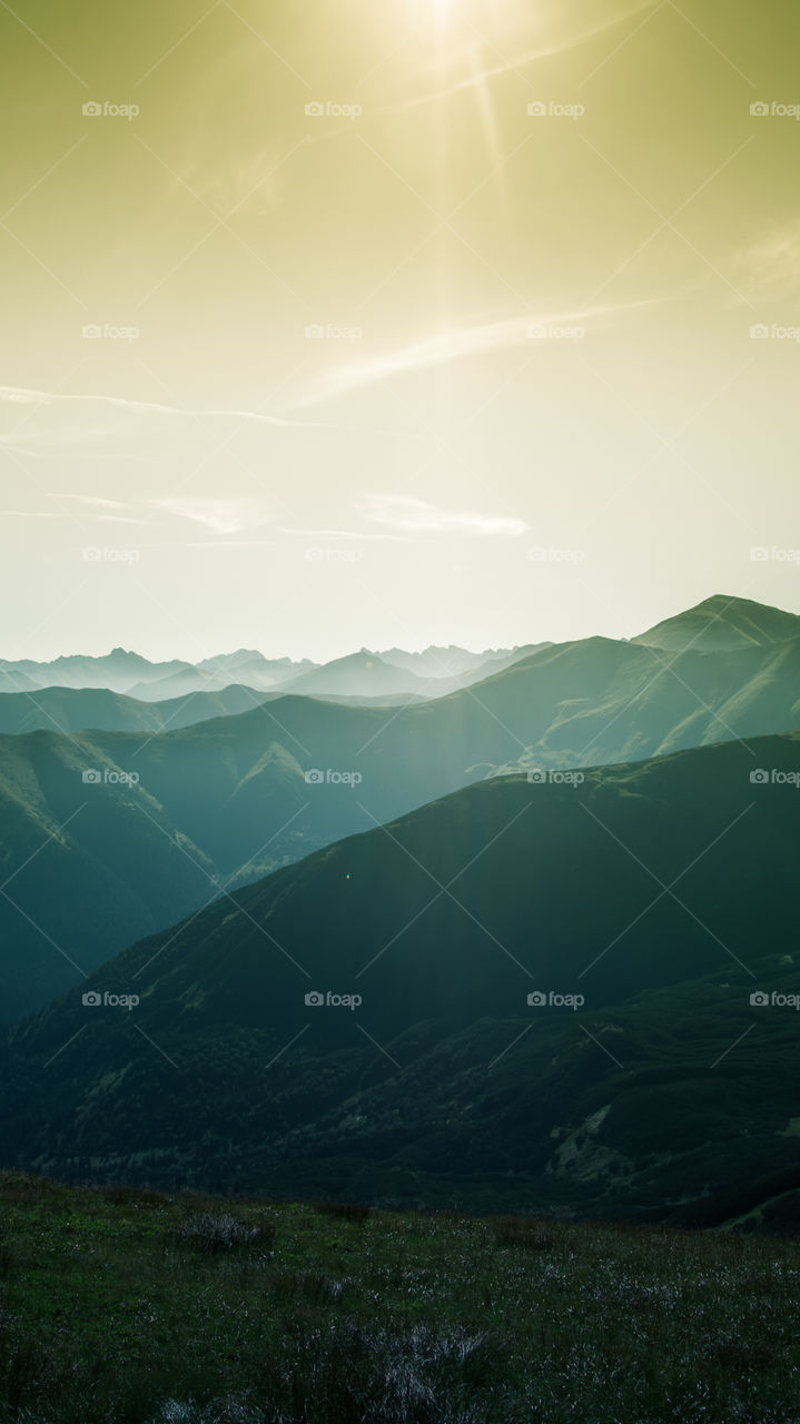 An inspiring mountain landscape. Tatry mountains in Slovakia. A beautiful wallpaper for smartphone screen. Warm summer haze, abstract gradient with perspective.