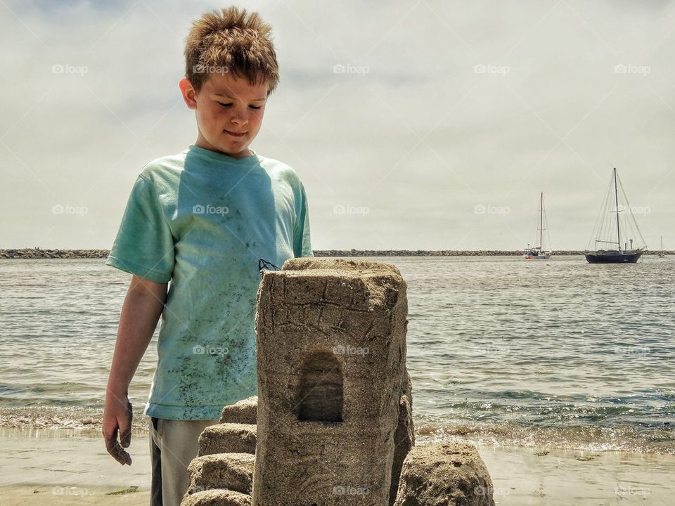 Boy Proud Of His Sand Castle. Building A Sand Castle