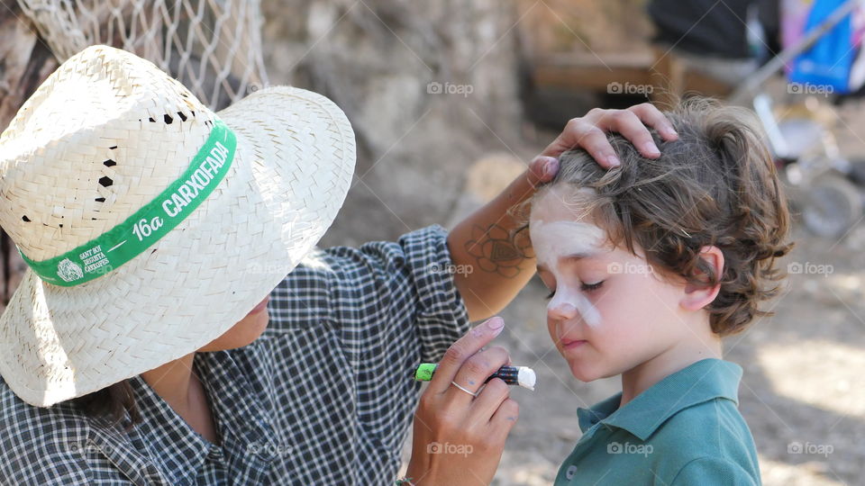 Mother applying cosmetic to his child