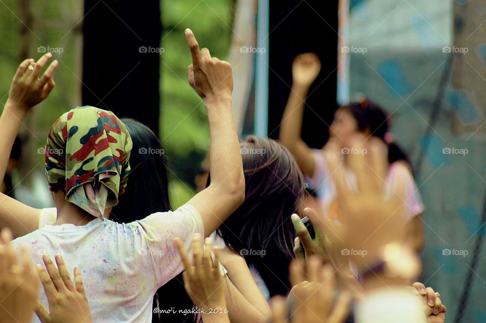 Rear view of group of people raising their arm