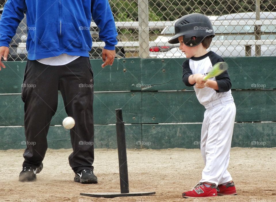 Playing T-Ball. Young Boy Taking A Swing At T-Ball
