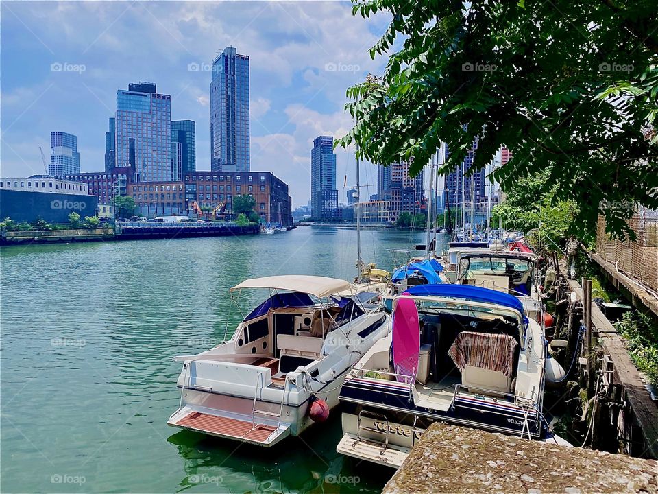 This beautiful scenario can be enjoyed at „Newtown Creek“ by the „Pulaski Bridge“ in „Long Island City“, Queens, NY. A great variety of boats is tied to the shore here which gives the area an idyllic look. 2023. Hypnotic Productions