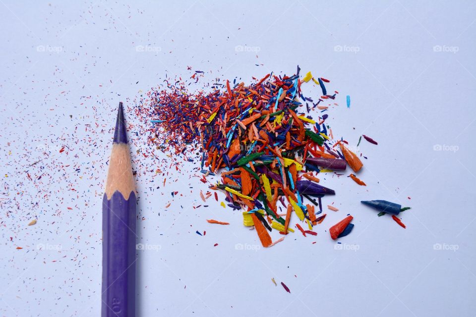 Colour pencil with pencil shavings against white background