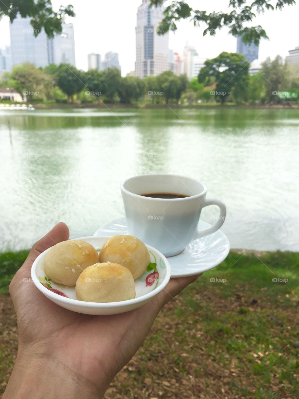 A cup of black coffee with bean and yolk cake