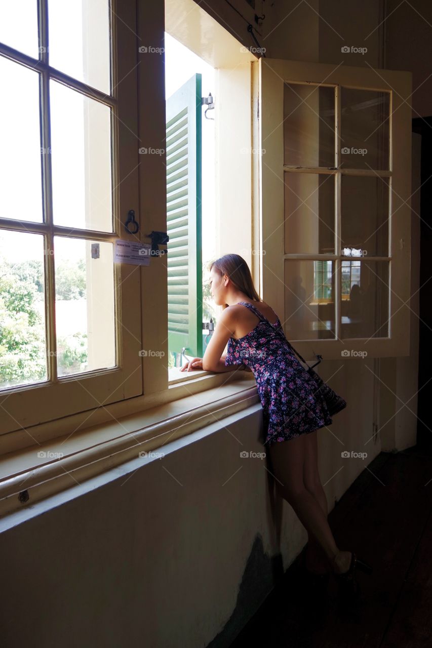 Girl by window waiting patiently 