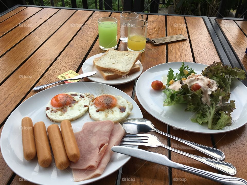 Eggs, bread, salad and juice are common meal in the morning 