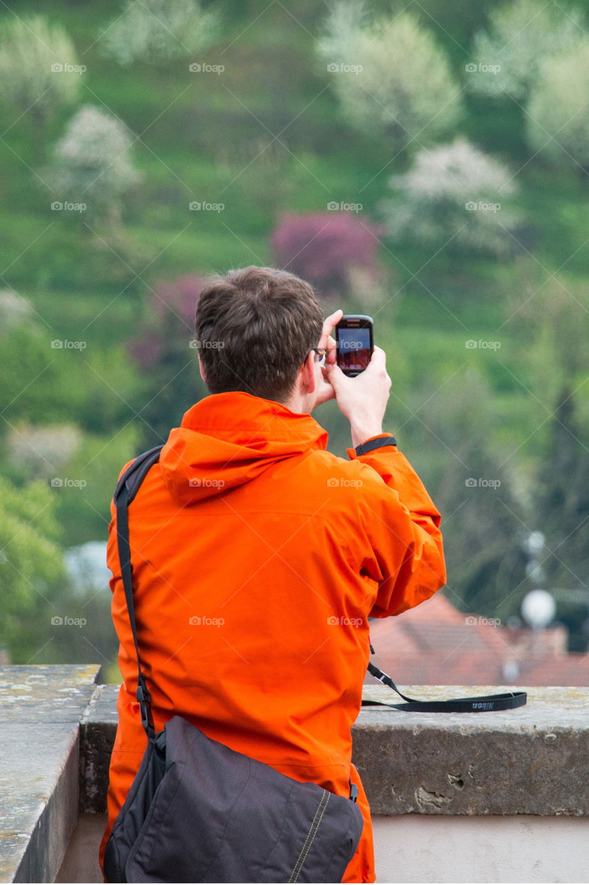 Tourist taking camera phone picture