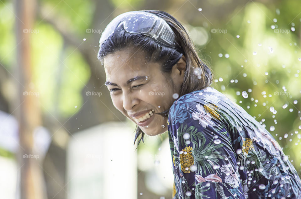 Asian woman play water in Songkran festival or Thai new year in Thailand.