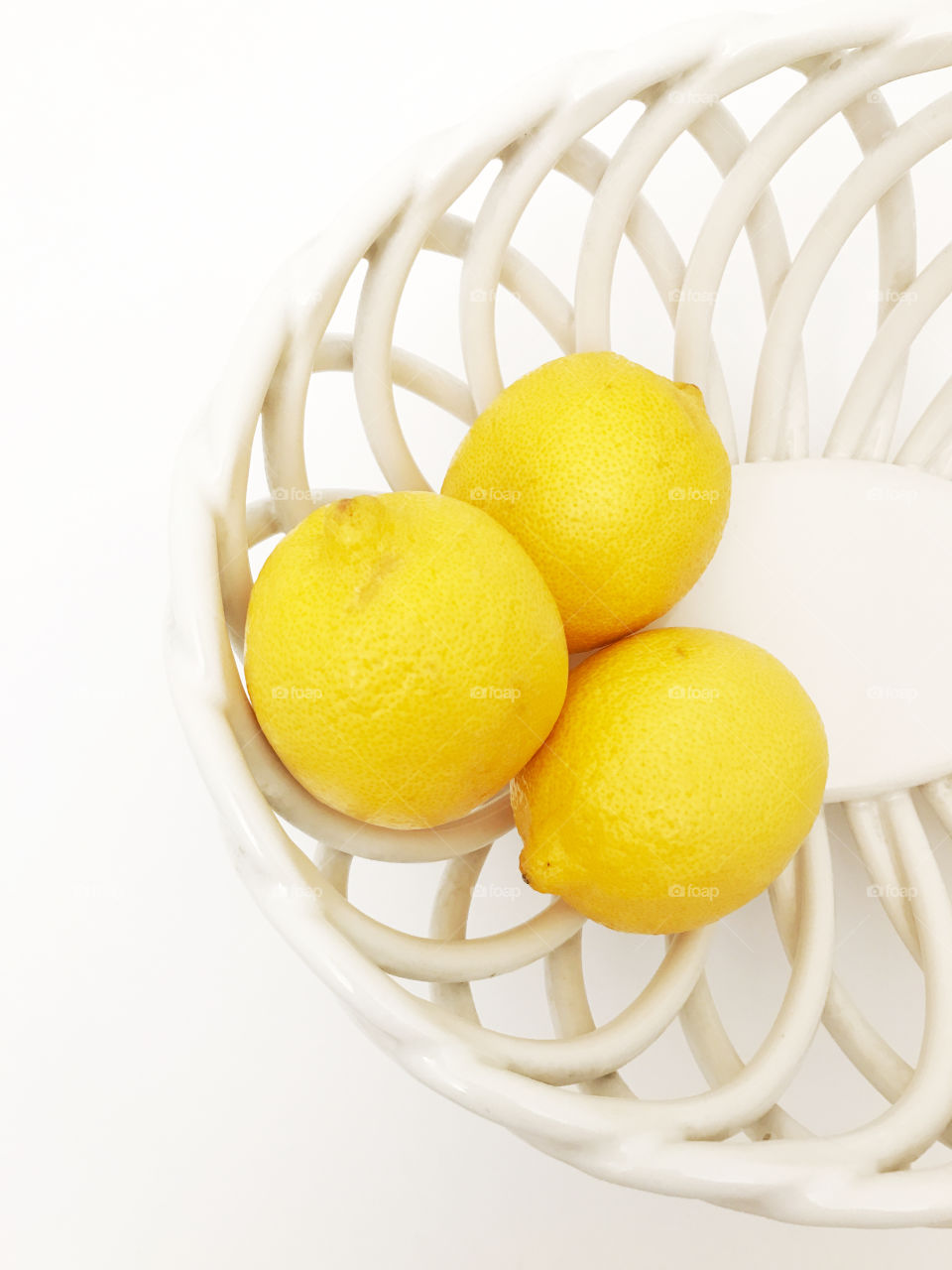 Looking down on a white bowl with three lemons!