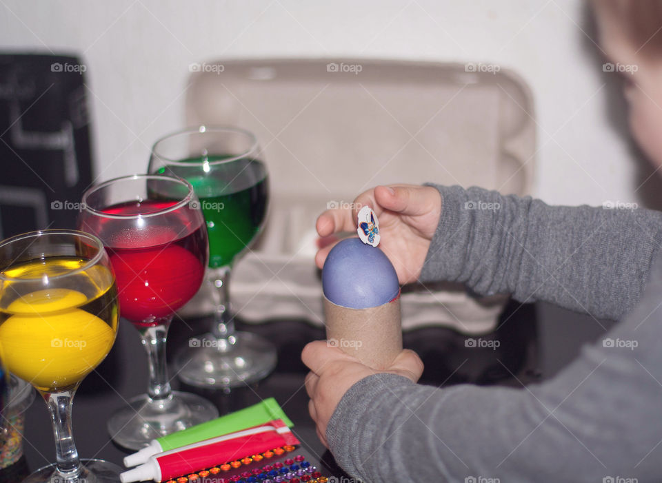 child decorates eggs for Easter