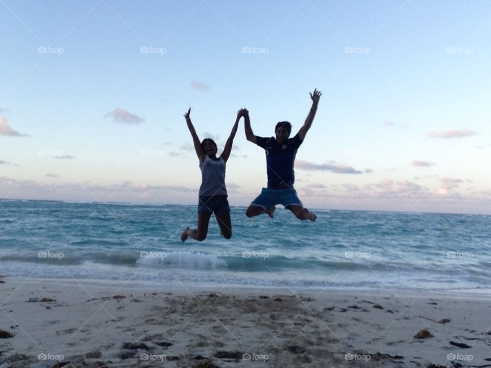 Couple jumping at the beach