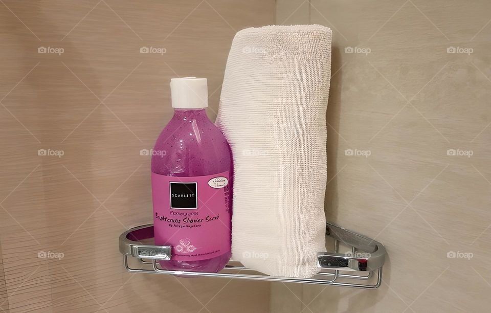 Close-up view of shower scrub beside white towel