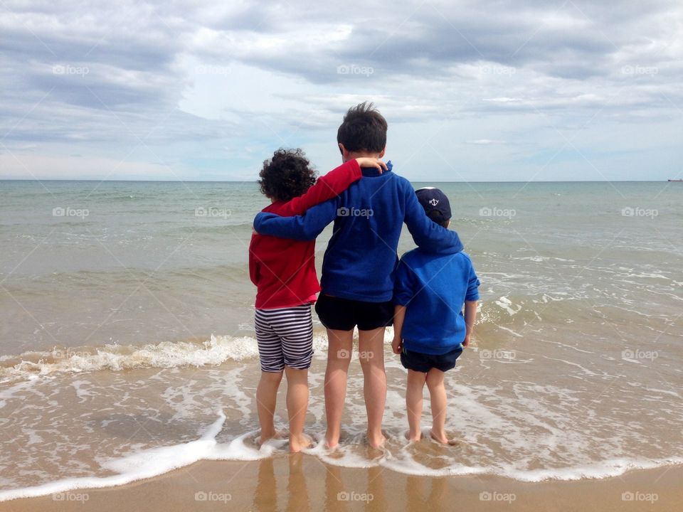 three children together  in the beach