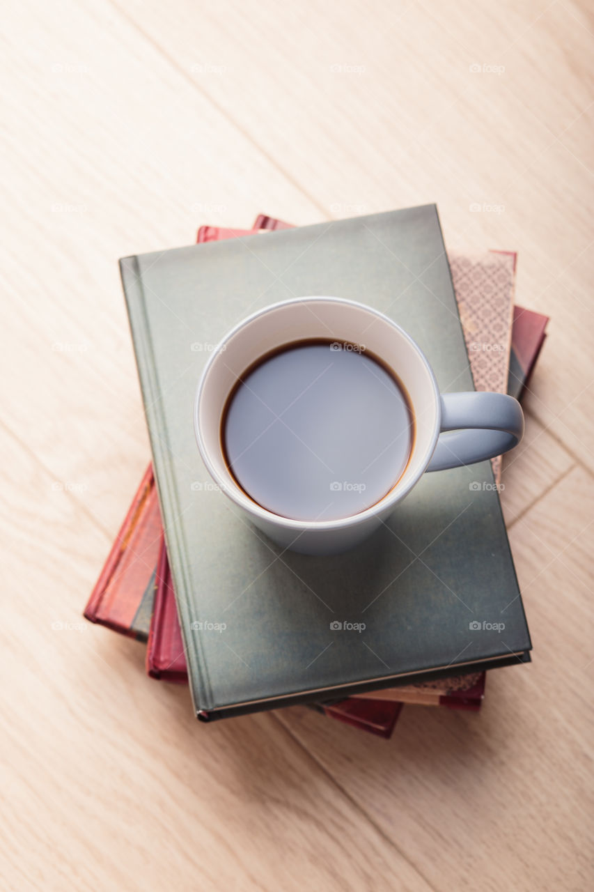 A few books with cup of coffee and cookies on wooden floor. Time for relax. Spending leisure time on reading. Cozy and comfortable. Relaxing 😌