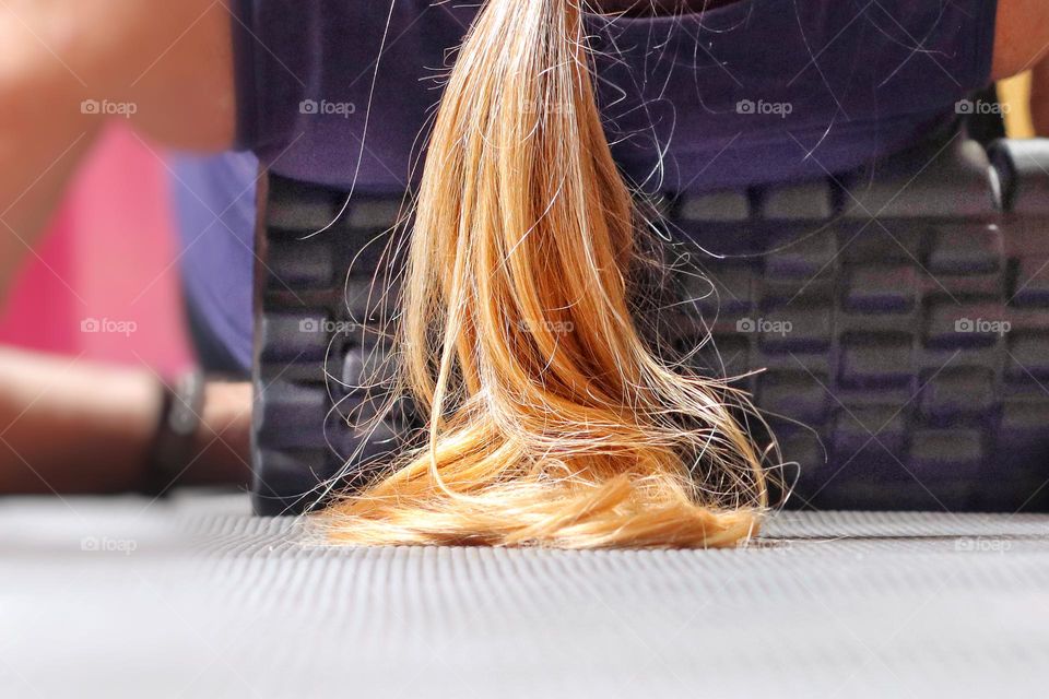 Woman with long hair exercising her back with a foam roller