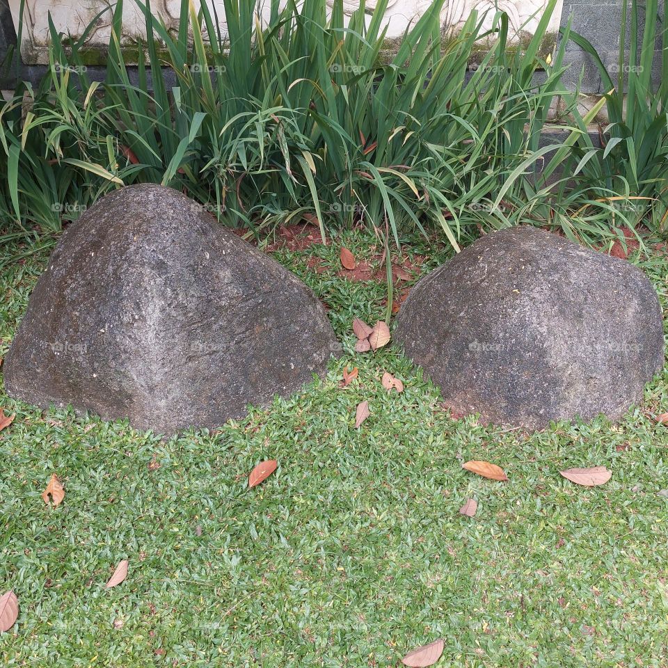 a large rock in the garden that can be used to sit