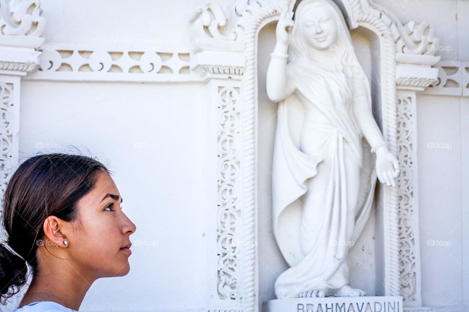 Girl and statue of Hindu goddess