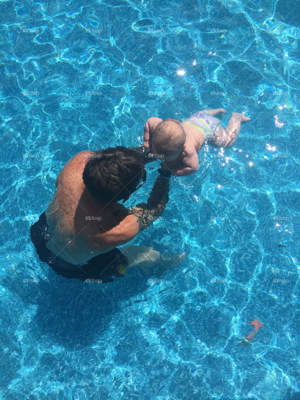 Baby’s second swim lesson, little boy with his Dad
