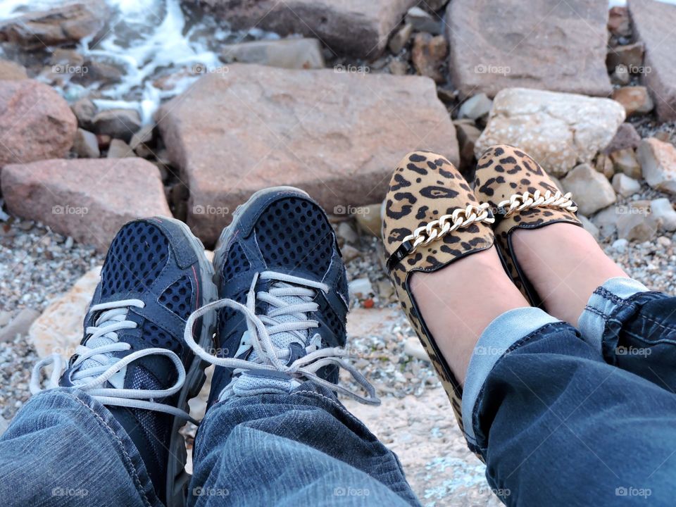 Couples feet at beach seawall