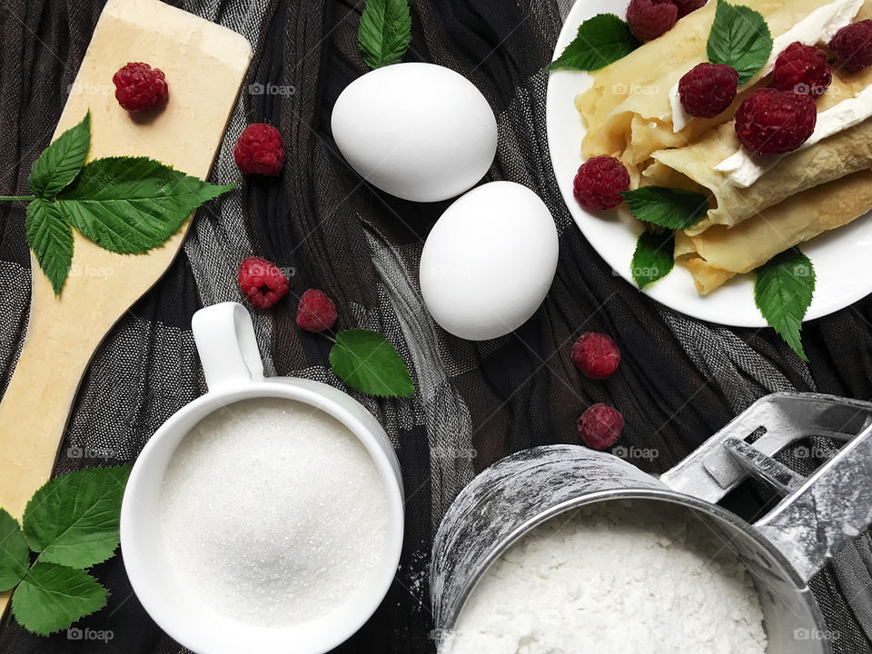 Overheard view of ingredients for preparation of pancakes with fresh raspberries 