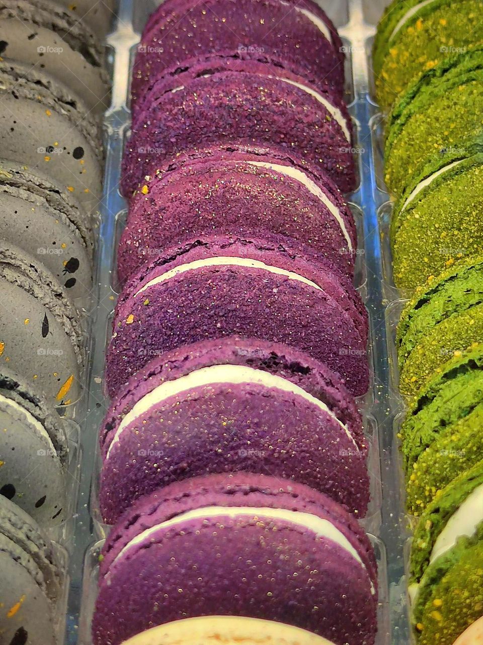 Row of purple macaron with blackcurrant flavor.  Paints in the confectionery department