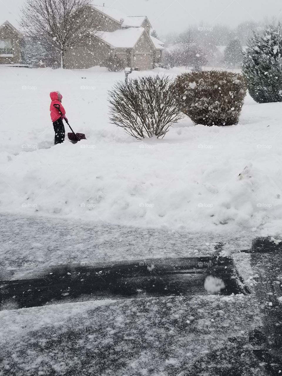 small child shoveling snow during winter storm Bruce