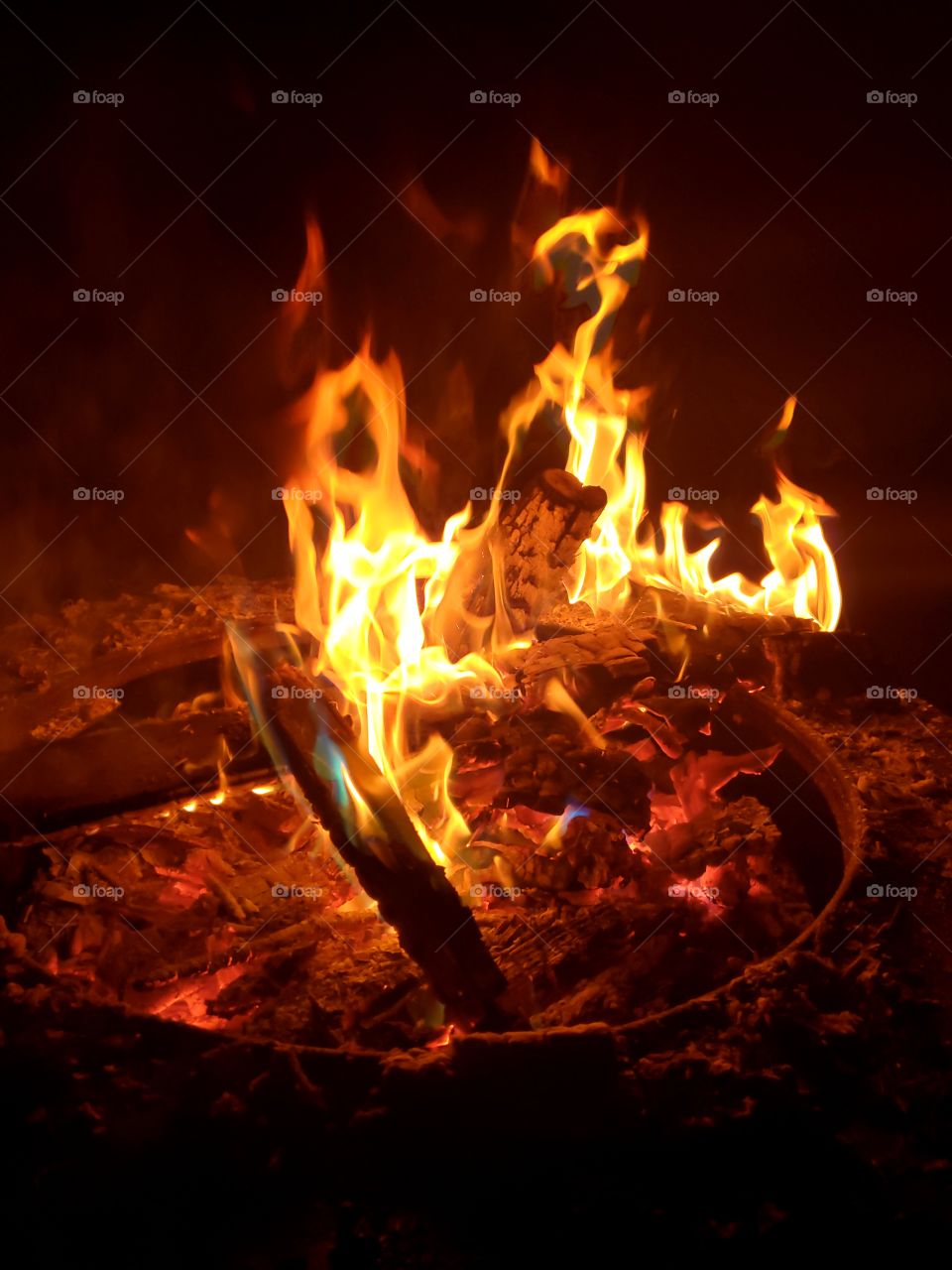 hot burning campfire with hint of blue flames and red smoke
