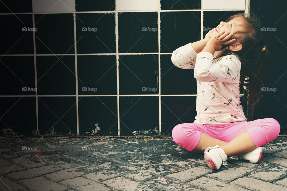 Cute happy girl sitting on floor