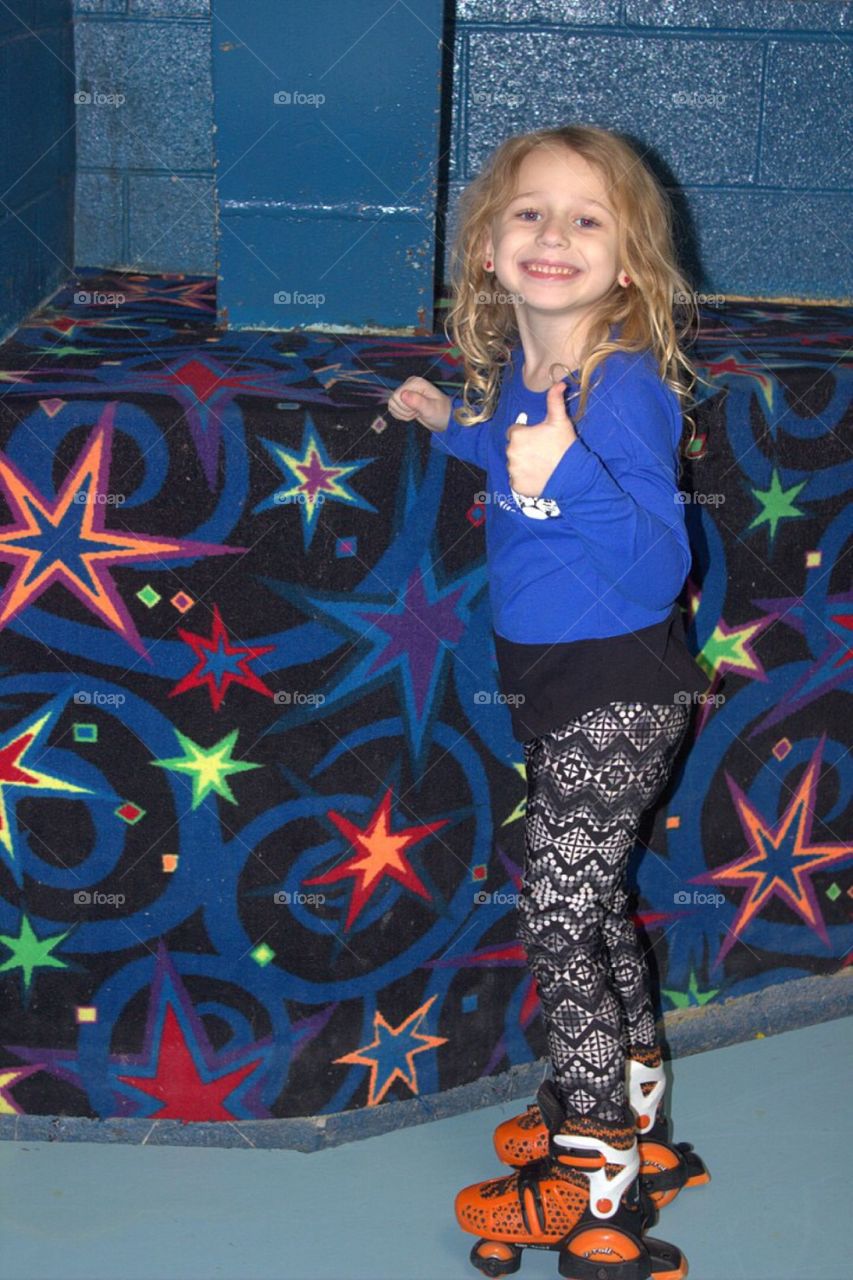 Portrait of skater girl standing and showing thumb up