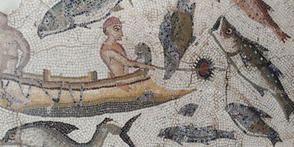 roman mosaic of man in boat sorrounded by fish
